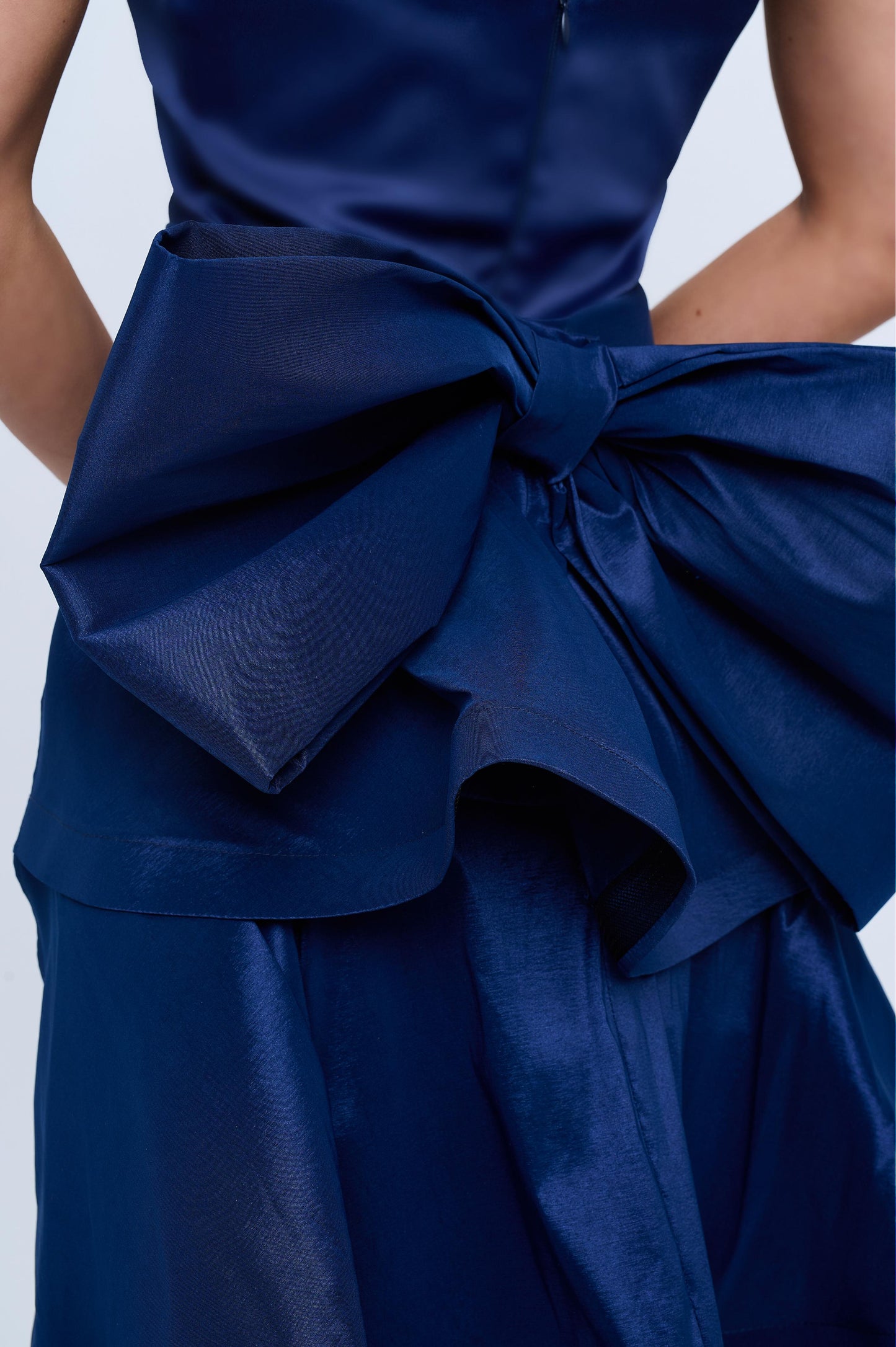 Strapless slit back dress and detachable belted oversized bow ruffle layered train